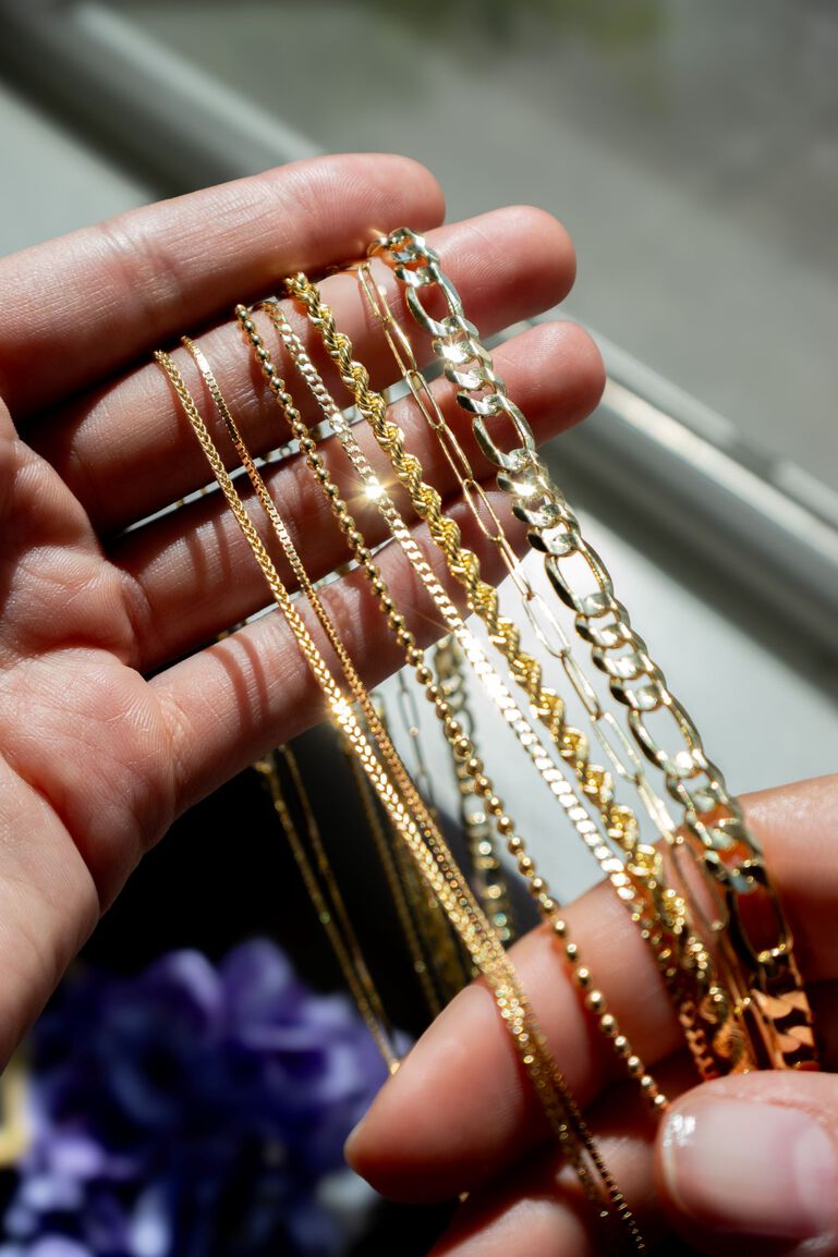 several varieties of gold chains glimmer in the light. 